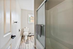 a bathroom with a toilet and a glass shower door at Spacious Colonial Large Groups Fire Pit in Brewer +58 photos