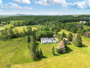 an aerial view of a white house on a green field at Spacious Colonial Large Groups Fire Pit in Brewer