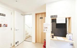 a room with a desk and a door with a window at Hananosato 池袋本店 池袋駅から近く 新宿渋谷銀座へ移動しやすい 周辺に 24 時間コンビニ 昔ながらの銭湯があり 人気の漫画本店も徒歩圏内 多様なタイプの客室を取り揃え 東京観光 都市散策 ショッピングにおすすめ in Tokyo