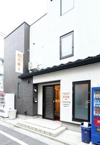 a building with a door on a street at Hananosato 池袋本店 池袋駅から近く 新宿渋谷銀座へ移動しやすい 周辺に 24 時間コンビニ 昔ながらの銭湯があり 人気の漫画本店も徒歩圏内 多様なタイプの客室を取り揃え 東京観光 都市散策 ショッピングにおすすめ in Tokyo