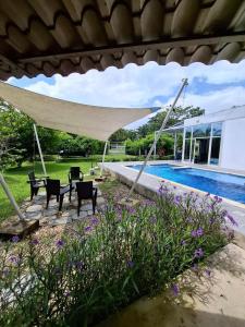 a patio with chairs and a umbrella next to a swimming pool at Maná Quinta Campestre in Carmen de Apicalá