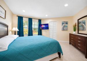 a bedroom with a blue bed and a tv at 3608 Orlando Vacational 1st floor in Orlando