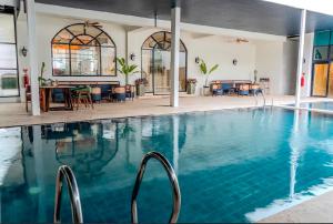 a swimming pool with blue water in a building at du PALAIS Hotel in Sultan Thaha Airport