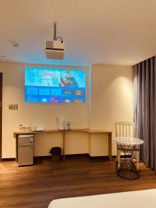 a room with a desk and a tv on the wall at The Cloud Hotel Bình Dương in Ga Phú Trung