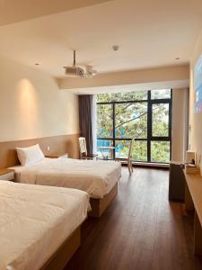 a hotel room with two beds and a large window at The Cloud Hotel Bình Dương in Ga Phú Trung