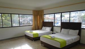 a hotel room with two beds and large windows at Hotel Paraiso Chipichape in Cali