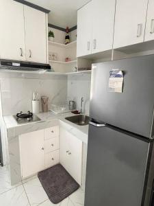 a kitchen with white cabinets and a stainless steel refrigerator at CJ cozy tiny home in Santa Barbara