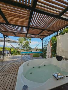 a hot tub on a deck with a hammock at Elementium Glamping in Cachipay