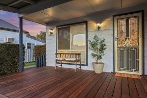 a porch with a bench on a wooden deck at Sunday Valley in Cessnock +30 photos