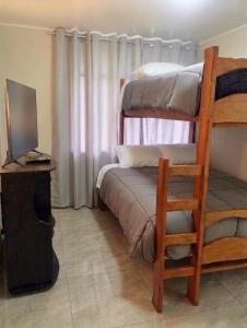 a bedroom with two bunk beds and a desk with a computer at La Terraza in Oxapampa