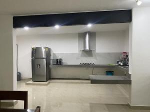 a kitchen with a stainless steel refrigerator in a room at Minimalist house with pool and patio in Chicxulub