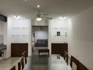 a dining room with a table and chairs and a couch at Minimalist house with pool and patio in Chicxulub