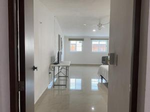 a hallway with a room with a bed and a television at Minimalist house with pool and patio in Chicxulub +17 photos