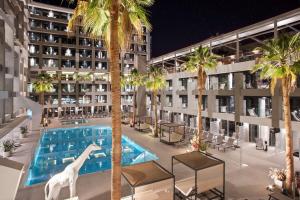 an exterior view of a hotel with a swimming pool and palm trees at INNSiDE by Meliá Palma Bosque in Palma de Mallorca