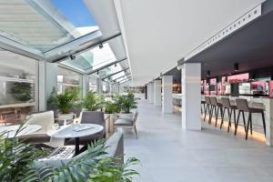 a restaurant with tables and chairs and windows at INNSiDE by Meliá Palma Bosque in Palma de Mallorca