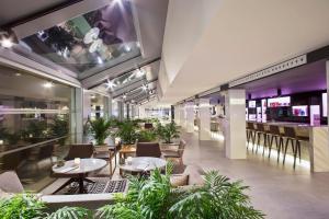 a restaurant with tables and chairs and a bar at INNSiDE by Meliá Palma Bosque in Palma de Mallorca