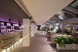 a restaurant with tables and chairs and plants at INNSiDE by Meliá Palma Bosque in Palma de Mallorca +79 photos