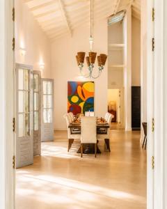 a dining room with a table and a painting on the wall at Hebron Gardens House in Kandy
