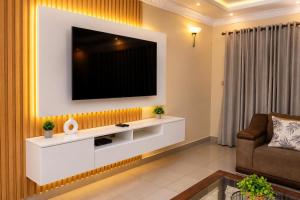 a living room with a television on a wall at Cozy Corner Monavale in Harare