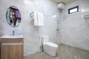 a bathroom with a toilet and a sink and a mirror at Hoi An Ocean Waves Homestay in Hà My Tây (2)