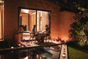 a man and a woman sitting at a table in a house at Terra Sayan in Ubud