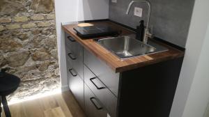 a kitchen with a sink and a stone wall at Style & Stone Guest House in Rome +127 photos