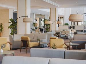 a lobby with couches and tables and chairs at Meliá Sitges in Sitges
