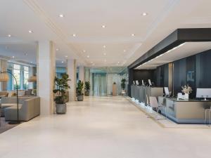 an office lobby with reception desks and potted plants at Meliá Sitges in Sitges