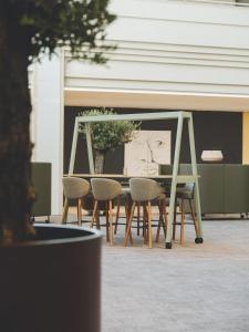 a table with chairs and a picture of a face at Meliá Sitges in Sitges