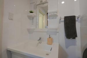 a white bathroom with a sink and a mirror at INA HOUSE Miyakojima 302 in Miyakojima +41 photos