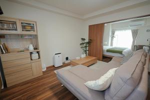 a living room with a couch and a bedroom at INA HOUSE Miyakojima 302 in Miyakojima