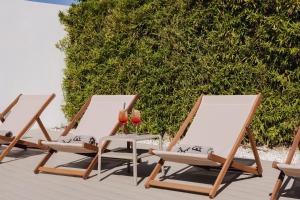 three lounge chairs and a table on a patio at INNSiDE by Meliá Barcelona Aeropuerto in El Prat de Llobregat
