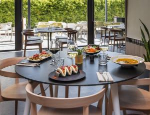 a table with plates of food on it in a restaurant at INNSiDE by Meliá Barcelona Aeropuerto in El Prat de Llobregat