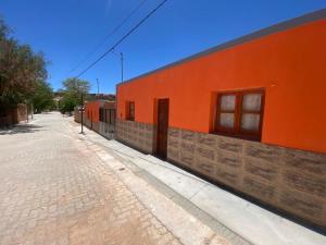 an orange building on the side of a street at Cielo andino in Antofagasta de la Sierra