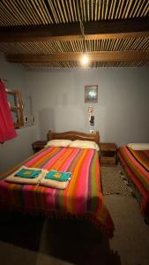 a bedroom with a bed with a colorful blanket at Cielo andino in Antofagasta de la Sierra