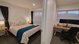 a bedroom with a bed and a desk with a computer at Huntington Hideaway in Hamilton +22 photos