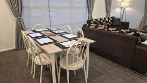 a dining room table with chairs and a couch at Huntington Hideaway in Hamilton