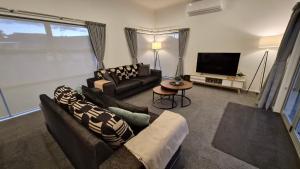 a living room with two couches and a television at Huntington Hideaway in Hamilton