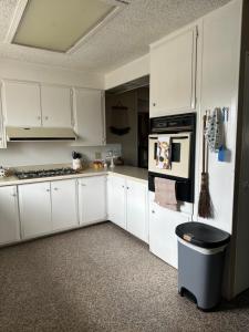 a kitchen with white cabinets and a stove top oven at Casa Isabel in Ensenada +19 photos