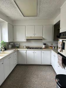 a white kitchen with white cabinets and appliances at Casa Isabel in Ensenada