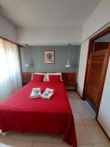 a bedroom with a red bed with two towels on it at Plaza hotel in Dolores