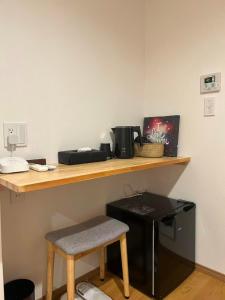 a wooden counter with a coffee maker and a stool at Leisure Hotel II 東中野 in Tokyo