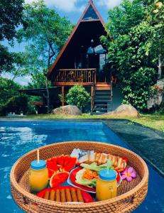 a tray of food in a basket next to a pool at Green Breeze Villa in Katugastota
