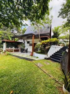 a house with stairs and a grass yard at Green Breeze Villa in Katugastota
