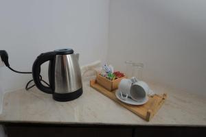 a coffee maker sitting on a counter with a wooden tray at Green Breeze Villa in Katugastota