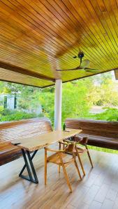 a wooden table and a bench on a porch at Ploythai Villa 2 in Haad Pleayleam