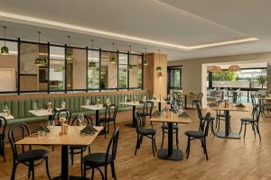 a restaurant with tables and chairs in a room at Courtyard by Marriott Darwin in Darwin