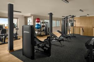 a gym with treadmills and chairs in a room at Courtyard by Marriott Darwin in Darwin