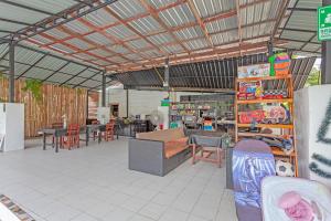 a living room with a couch and tables and chairs at Natai House Resort นาใต้เฮ้าส์ รีสอร์ท in Natai Beach