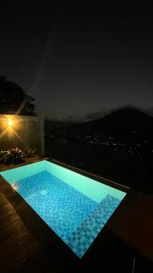 ein Schwimmbad bei Nacht mit Aussicht in der Unterkunft Pinggan Infinity - Private Pool Villa in Kintamani in Gretek